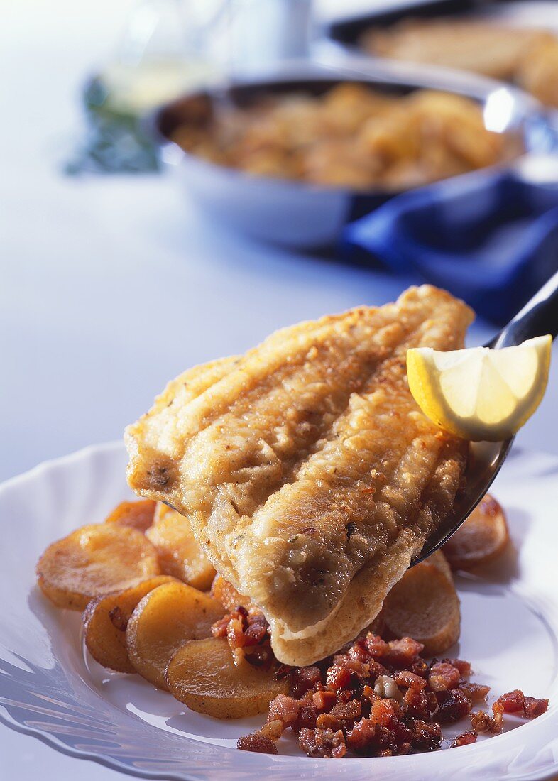 Fried plaice fillets with bacon and fried potatoes