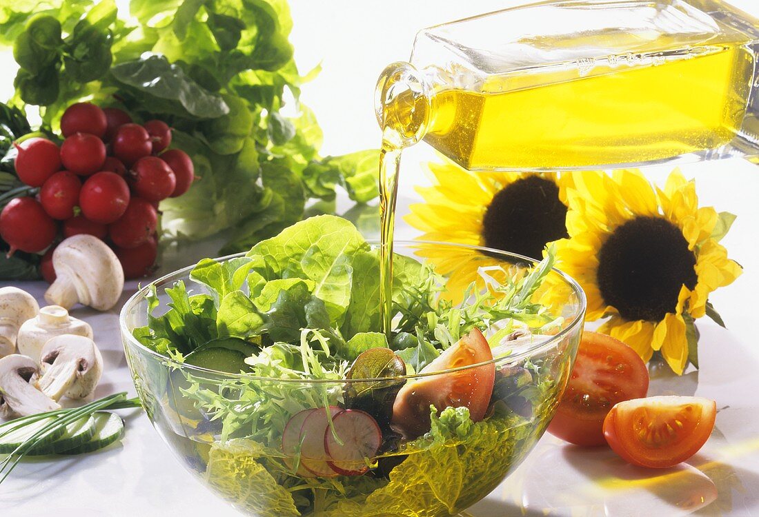Gemischter Salat wird mit Sonnenblumenöl angemacht