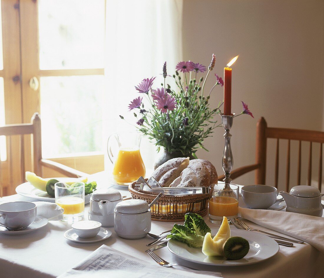 Laid breakfast table with baked goods, juice and fruit