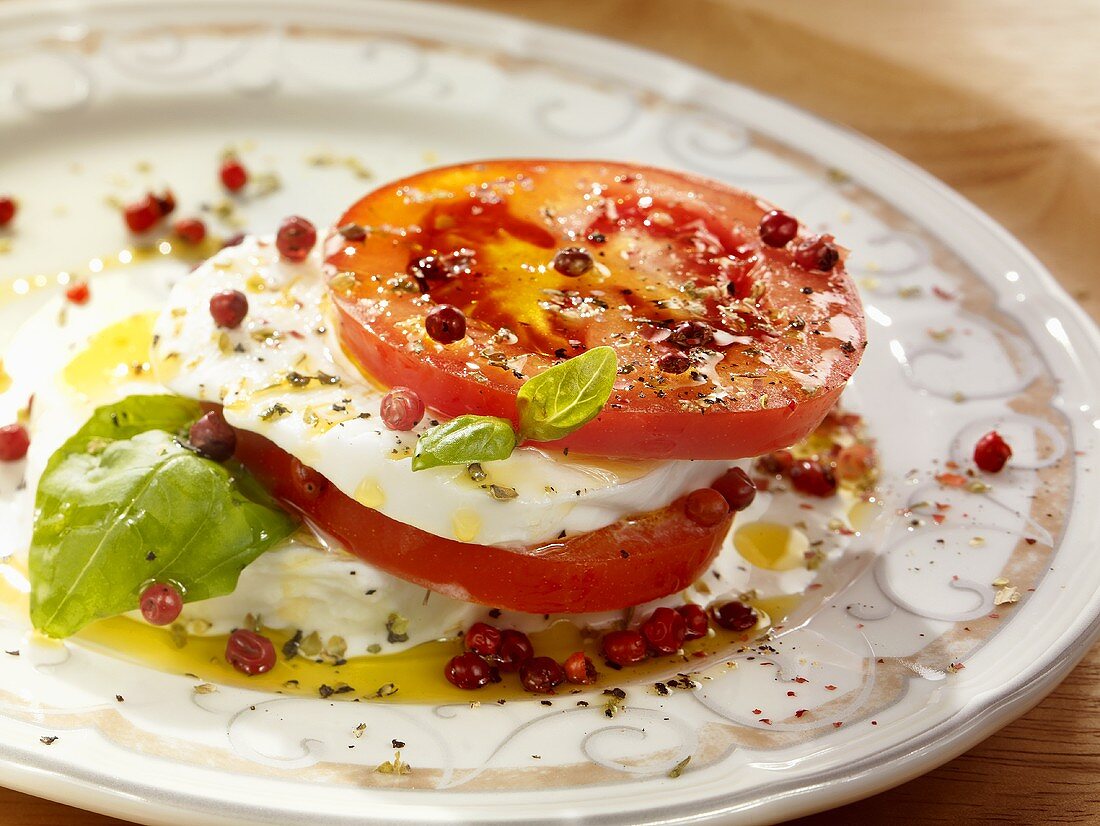Tomatoes with mozzarella, basil, olive oil and pink peppercorns