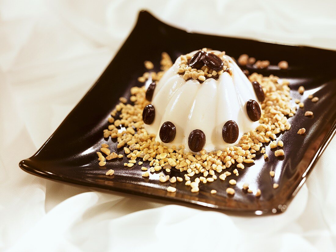 Vanilla blancmange with chocolate-coated coffee beans and chopped nuts