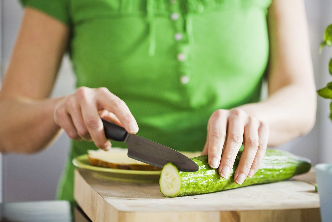 Woman slicing a cucumber