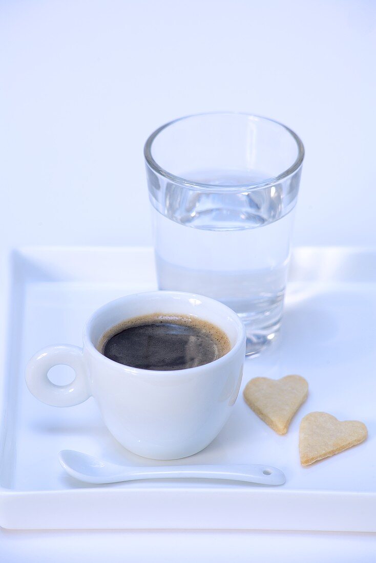 Espresso, Herzkekse und Glas Wasser