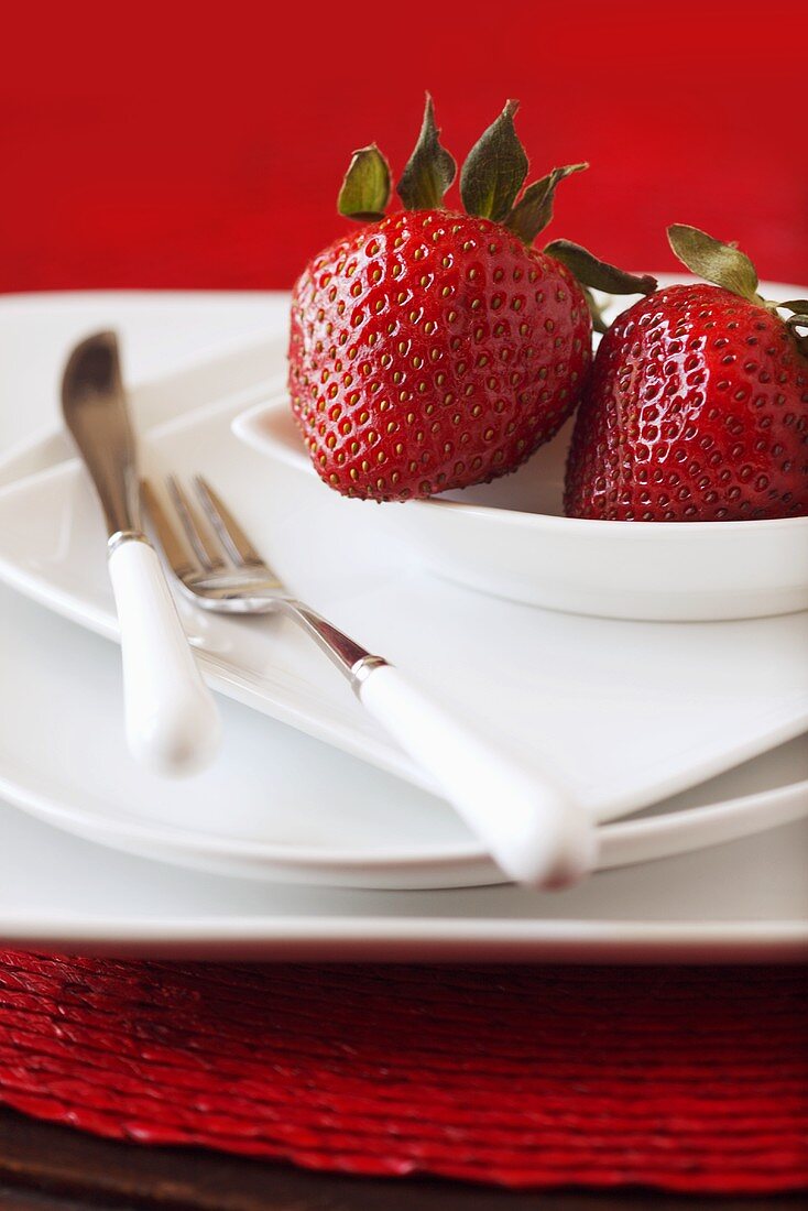 Two Strawberries on Stacked White Plates