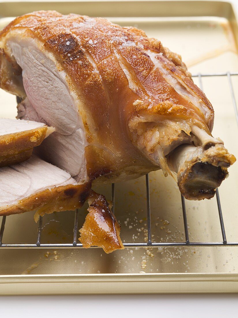 Roast pork on the bone with crackling, partly carved