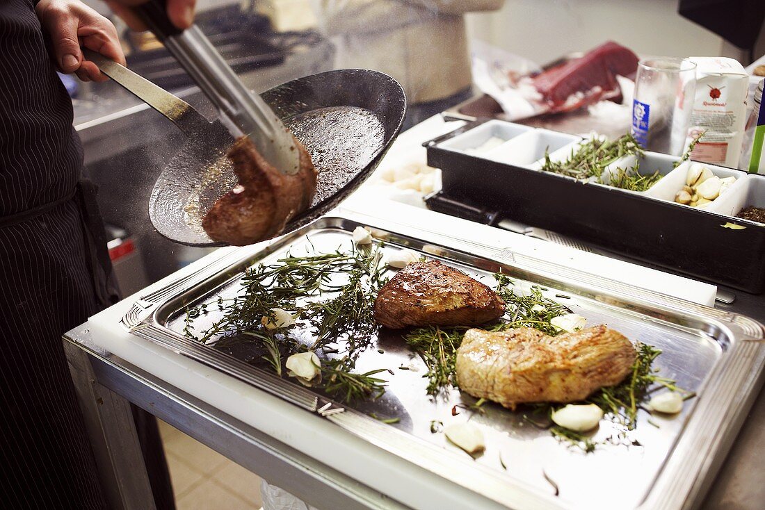 Placing the fried meat on a tray with herbs