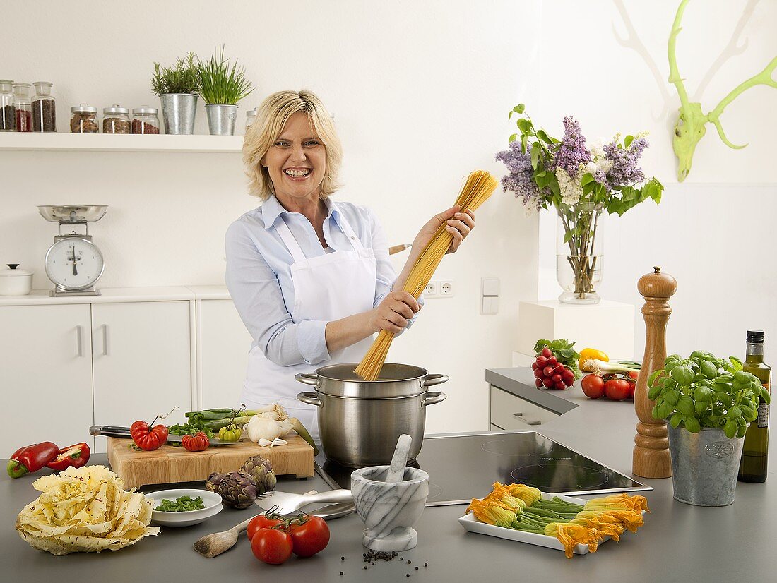 Lachende Frau mit Spaghetti in den Händen