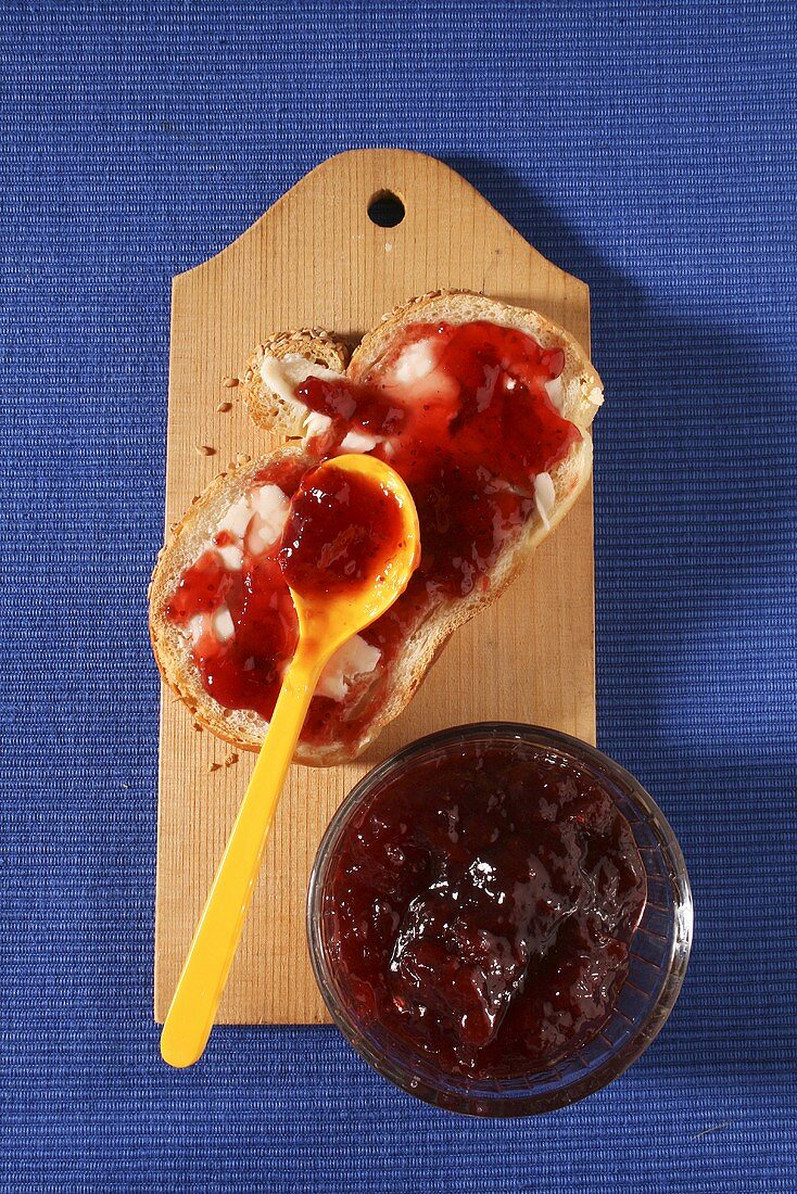 Slice of bread and jam with pot of jam
