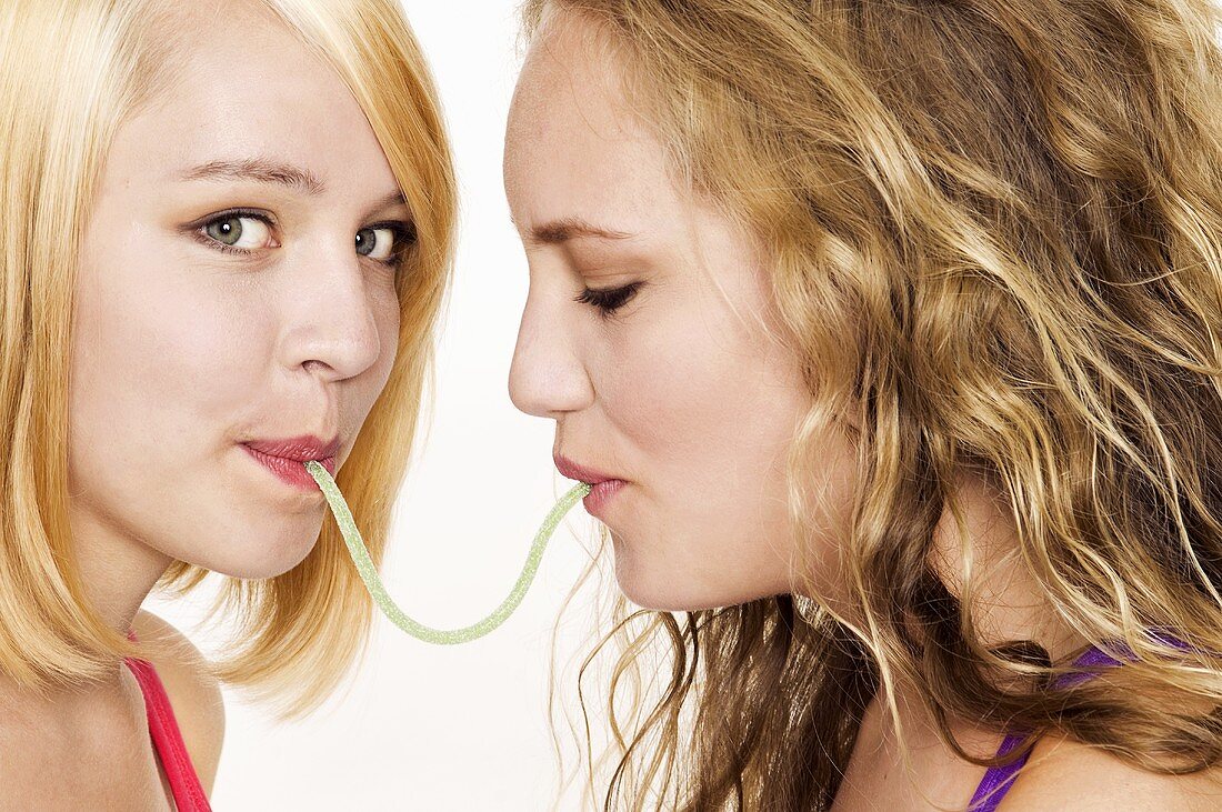 Two women eating a sour snake