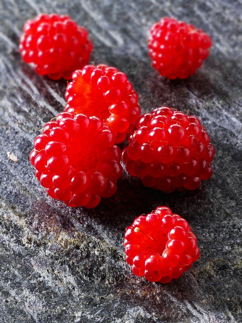 Several Japanese wineberries on a stone board