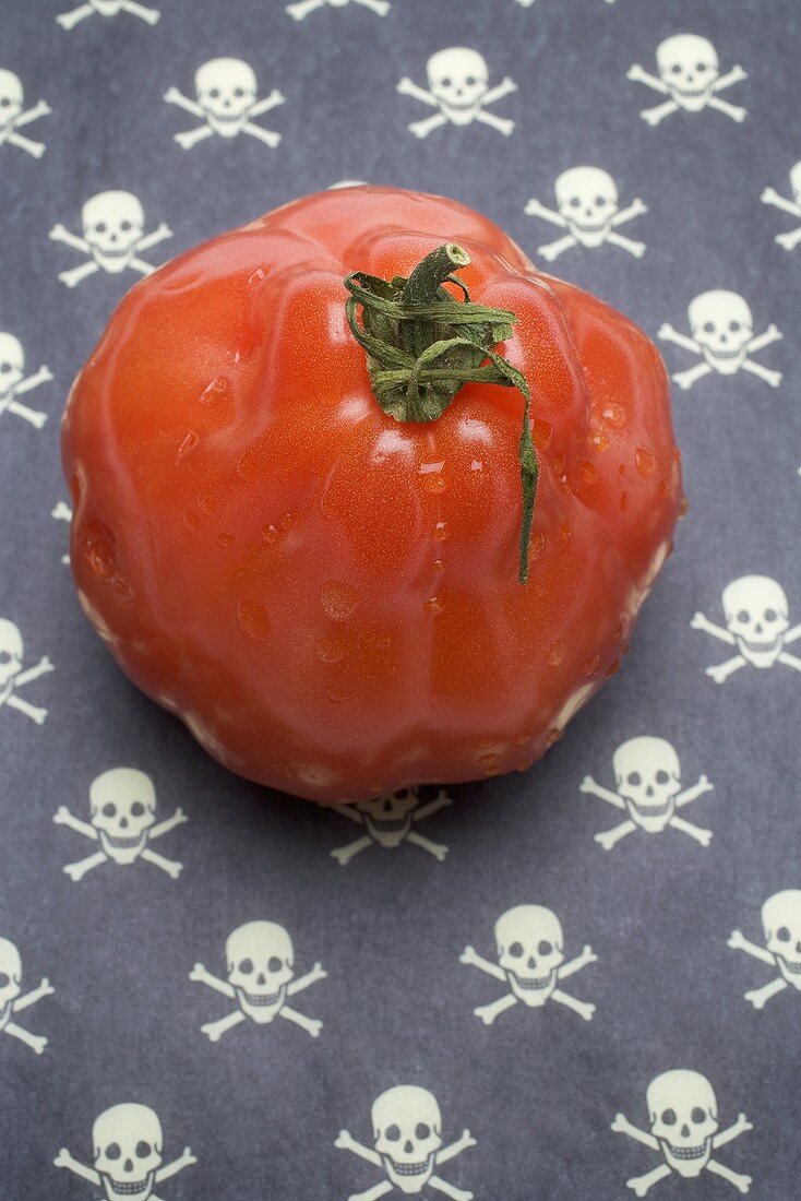 Tomato on a patterned background (skulls and crossbones)