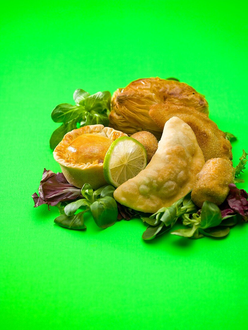 Assorted pies and pasties on salad leaves