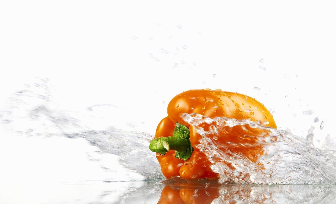 Orange pepper with splashing water