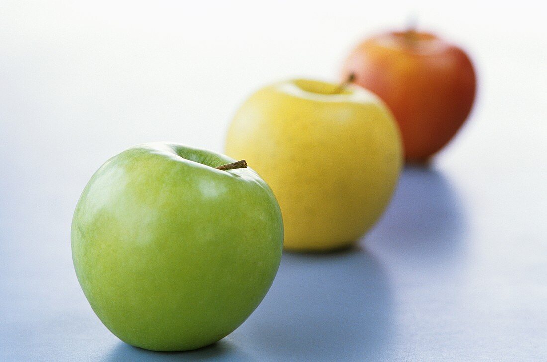 Drei verschiedene Äpfel, aufgereiht