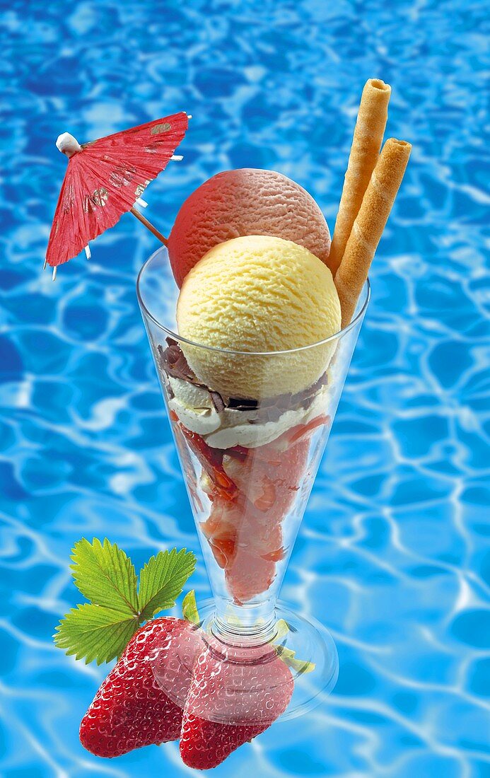 Ice cream sundae with strawberries, swimming pool in background
