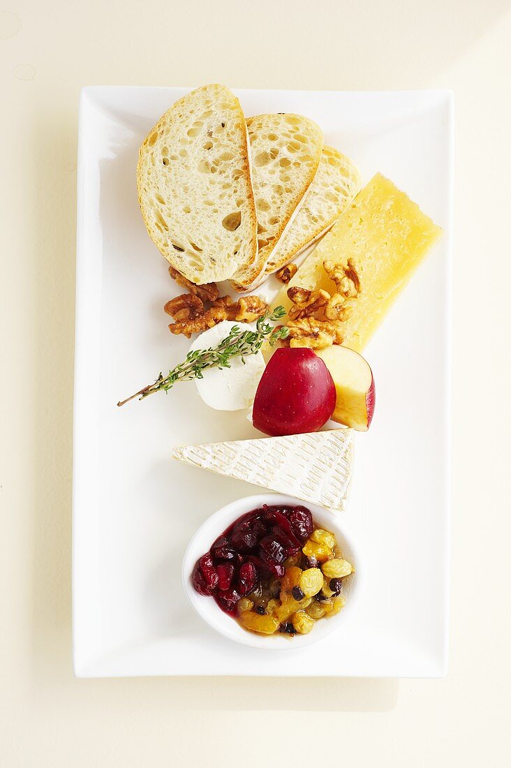 Käseplatte mit Brot, Nüssen und Früchten