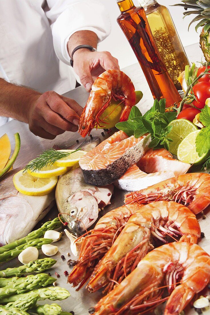 Chef with fish, prawns and other ingredients