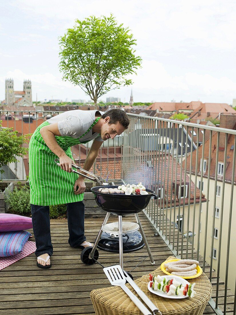 Man preparing barbecue on balcony