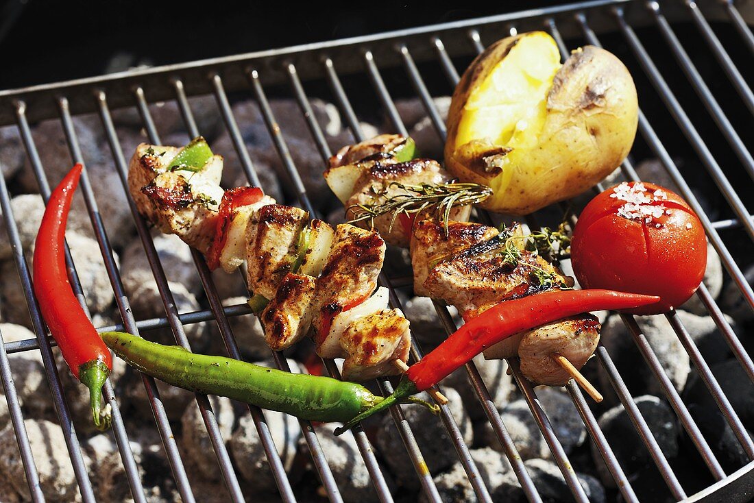 Pork kebabs and vegetables on barbecue rack