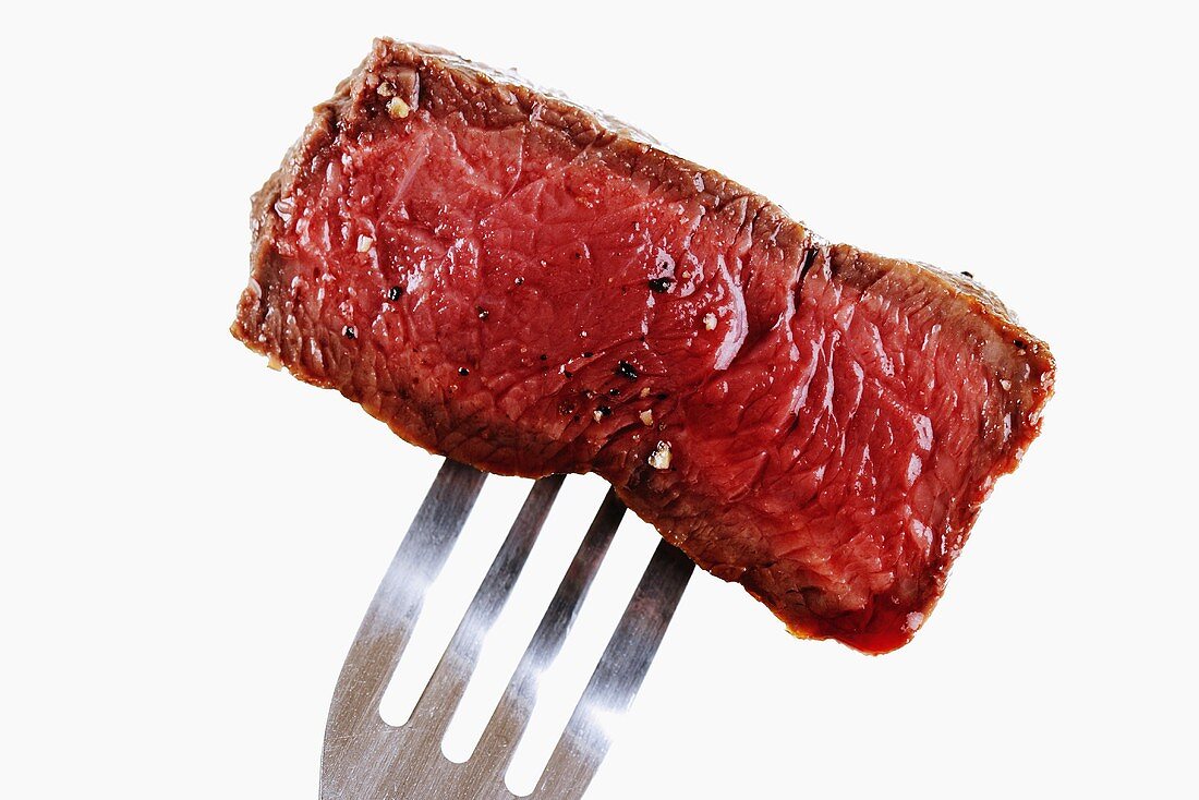 Piece of fried fillet steak on fork