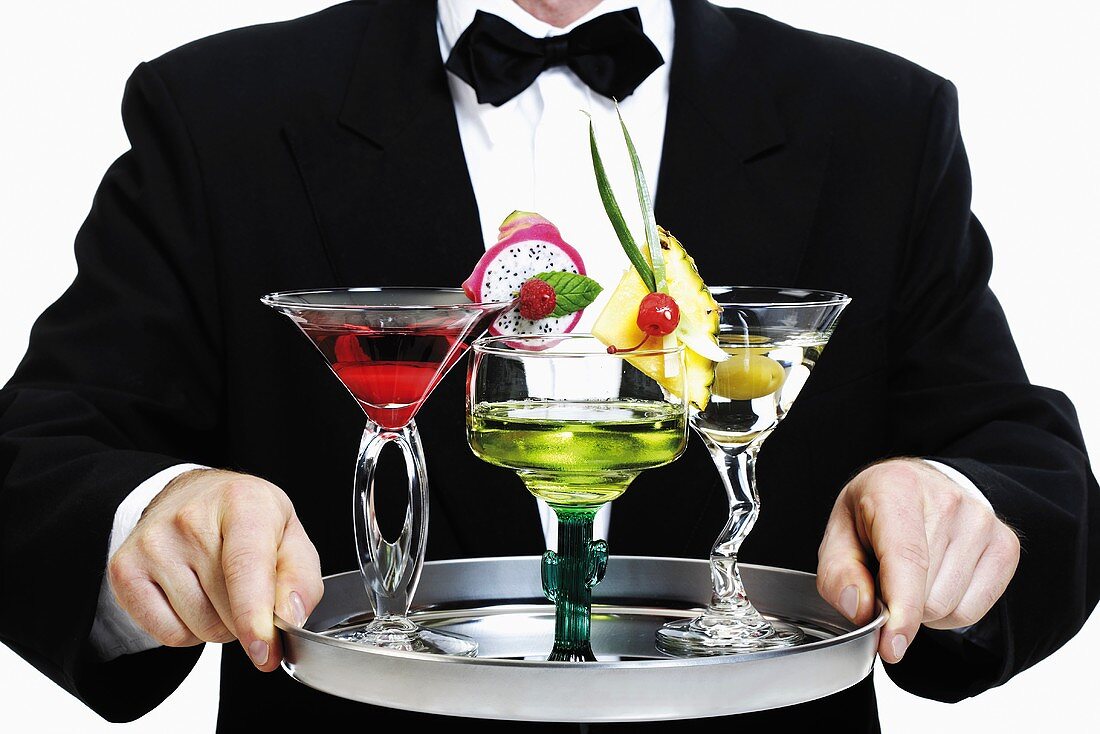 Bartender serving tray of different cocktails