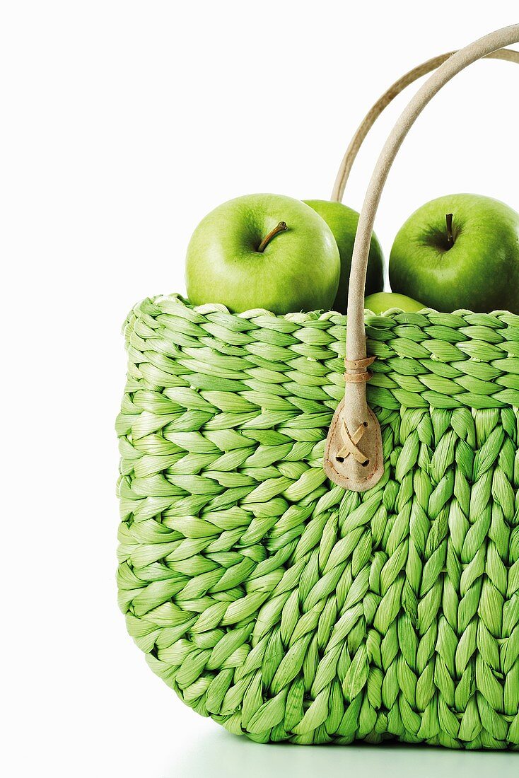 Granny Smith Äpfel in grünem Einkaufskorb