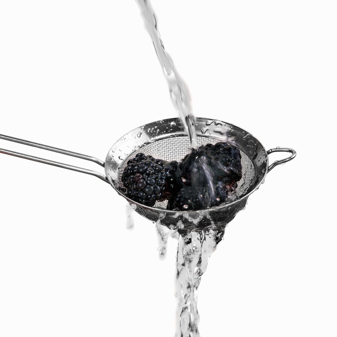 Washing blackberries in a sieve