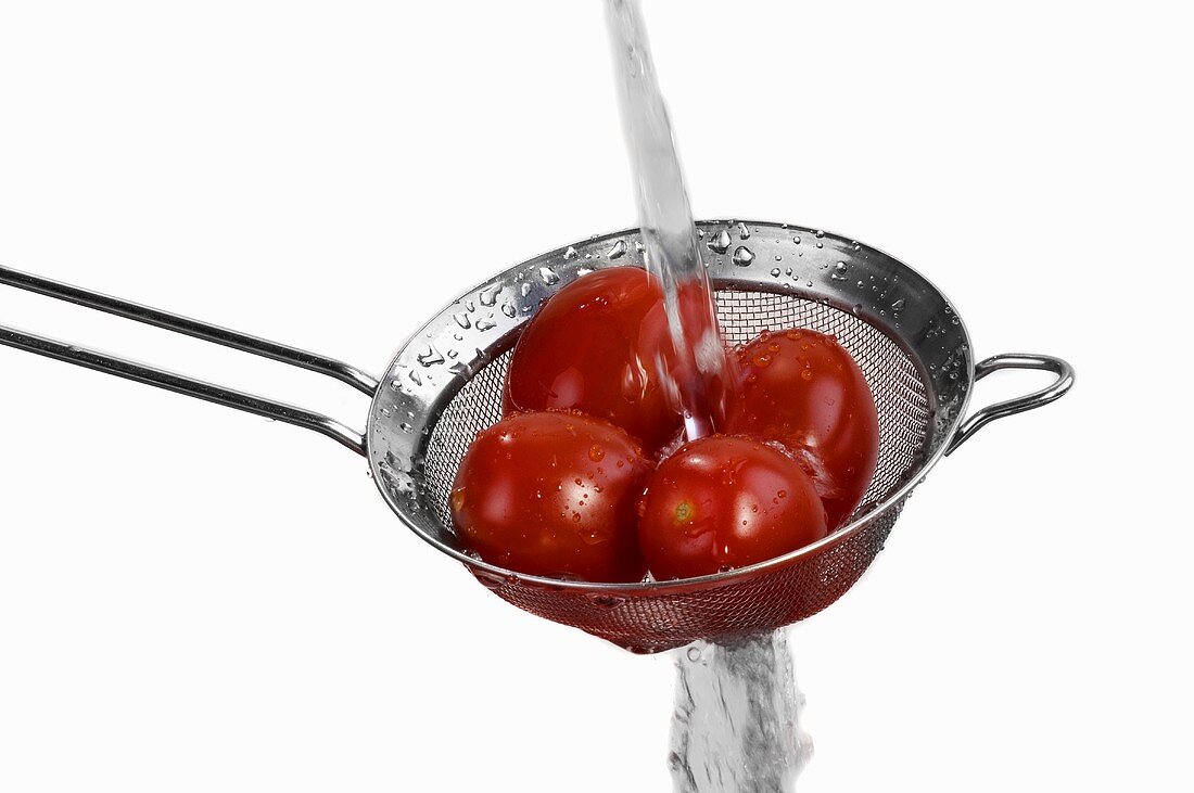 Tomaten in einem Sieb waschen