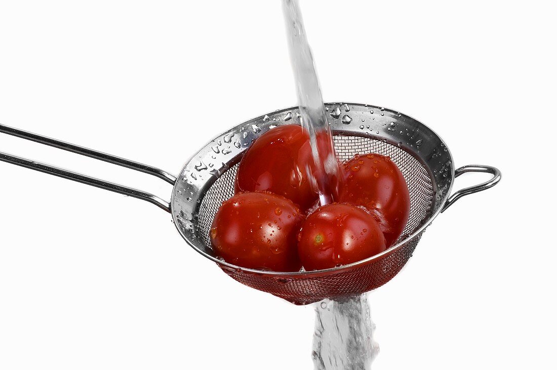 Washing tomatoes in a sieve