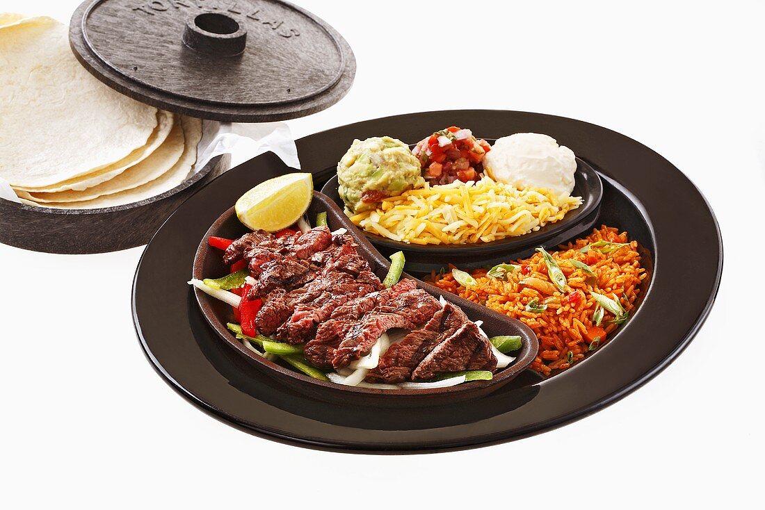 Beef fajita with accompaniments and tortillas