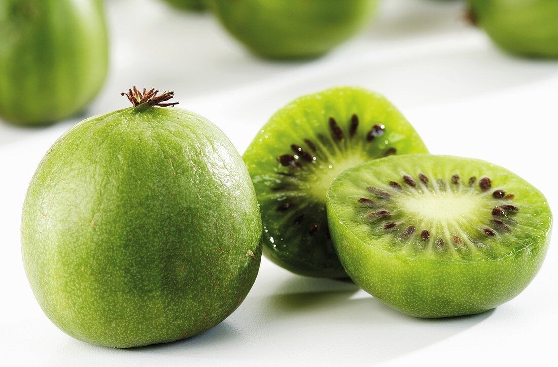 Whole and halved kiwi fruits, close-up
