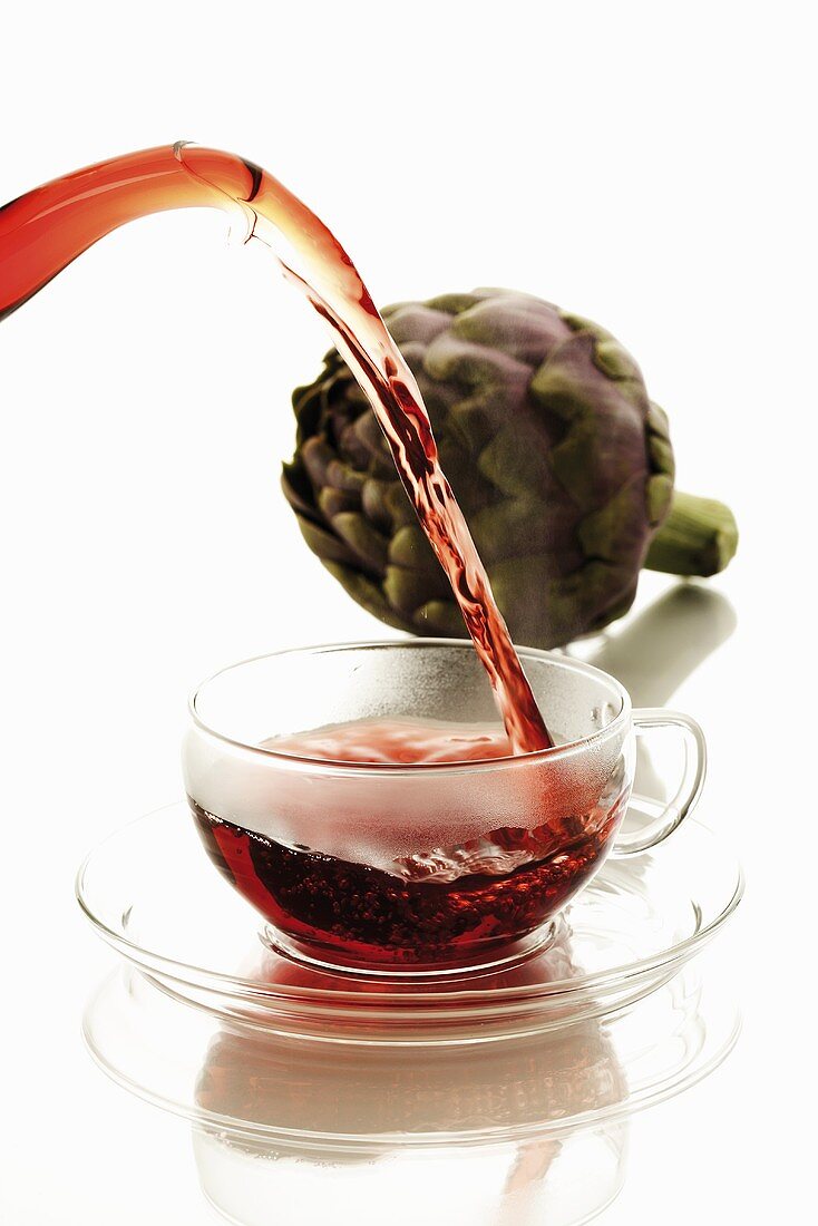 Artichoke tea being poured into glass cup