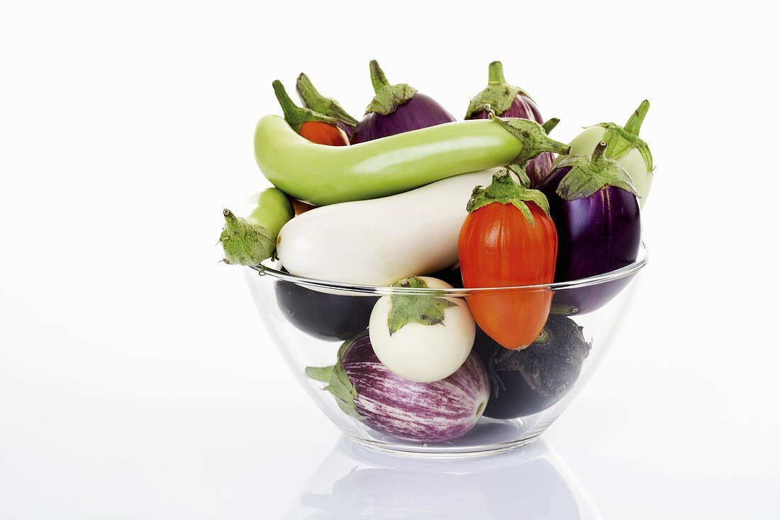 Various types of aubergines in glass bowl