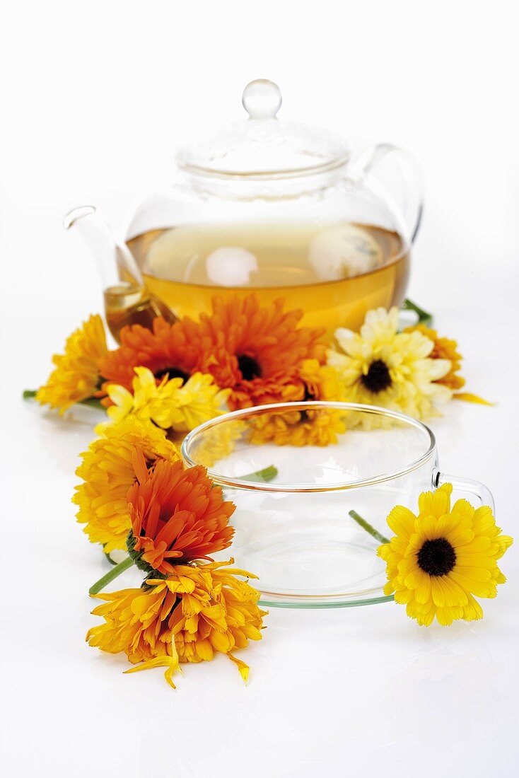 Marigold tea in glass teapot, marigolds, glass cup