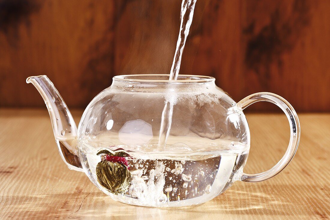 Pouring hot water into teapot (with tea flower)