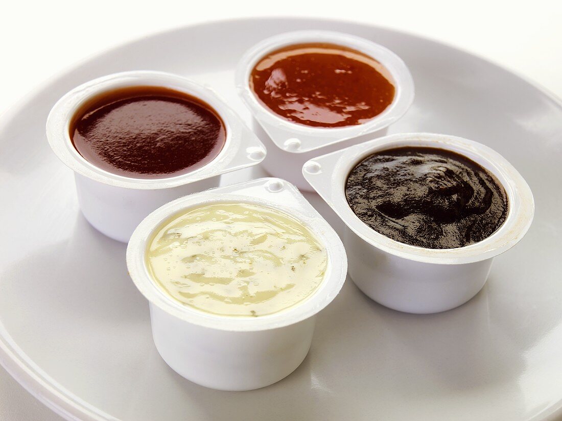 Four different dips in plastic pots