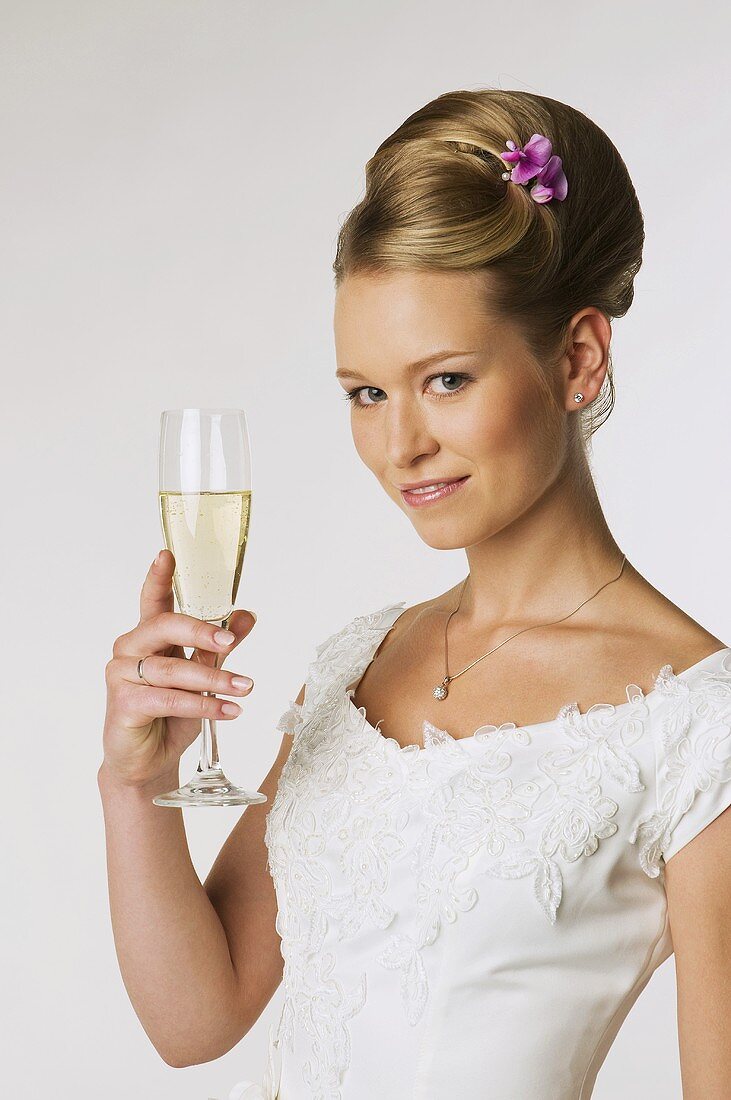 Young bride holding champagne glass, portrait