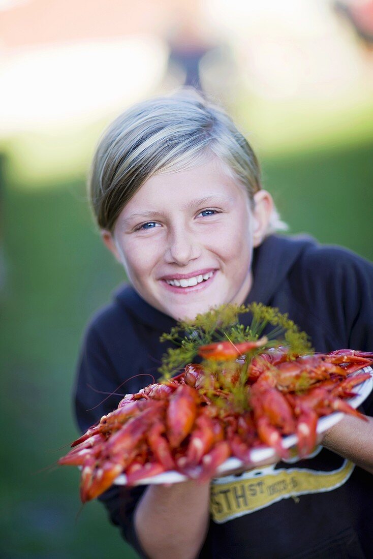 Girl holding a platter of cooked crayfish