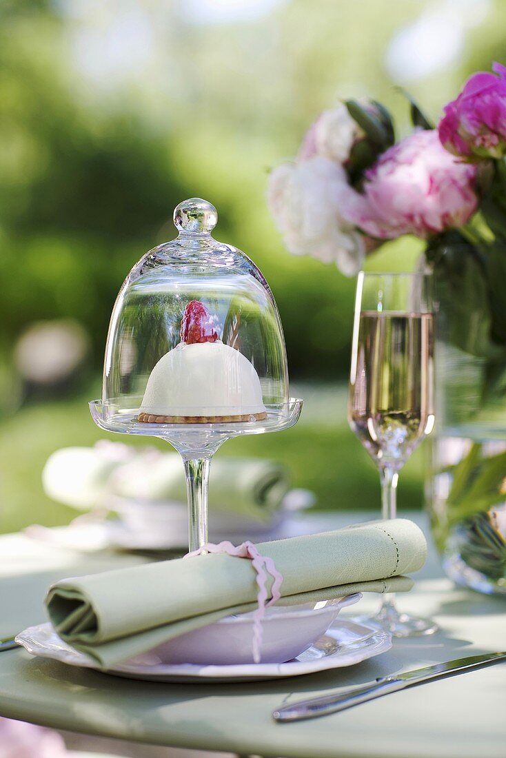 Gedeckter Tisch mit Törtchen und Champagner im Freien