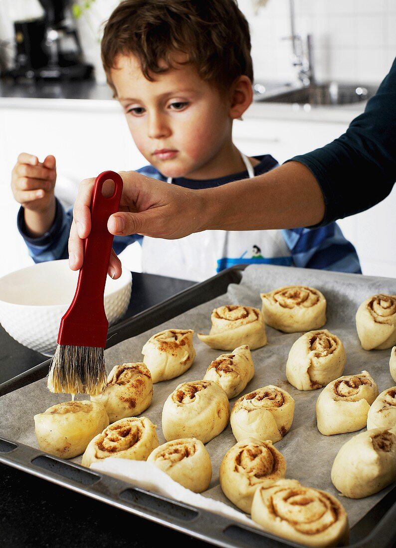 Mother and son making cinnamon buns
