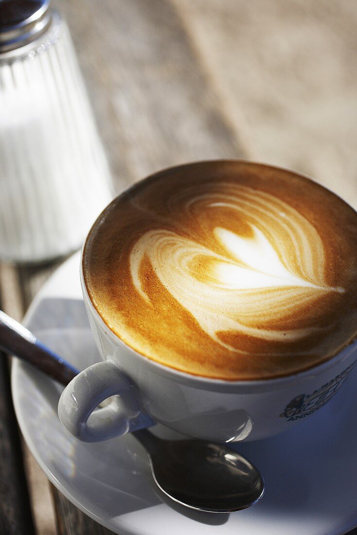 Eine Tasse Cappuccino mit Herzmuster im Milchschaum