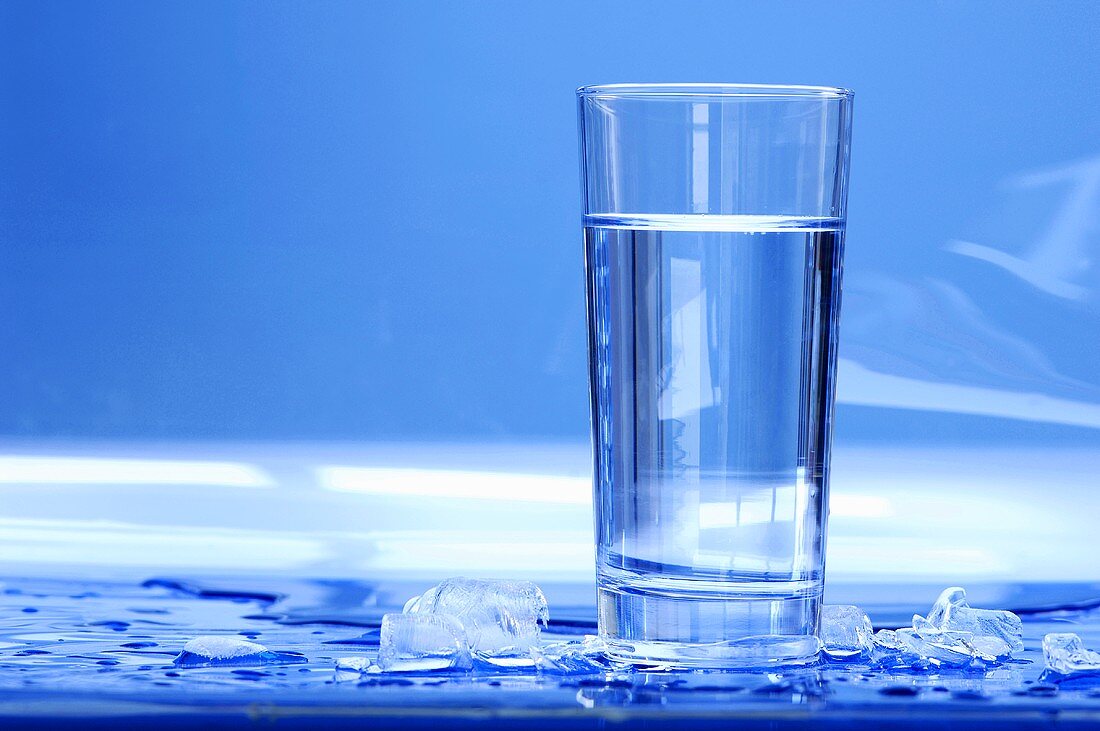 Glass of water with ice cubes, close-up