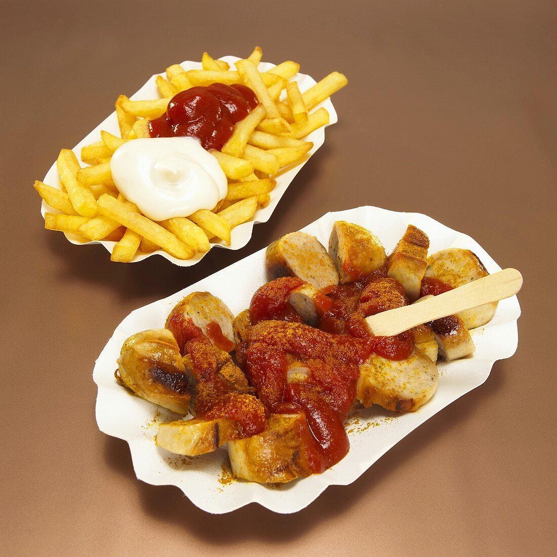 Currywurst and French fries with sauce in plate, close-up