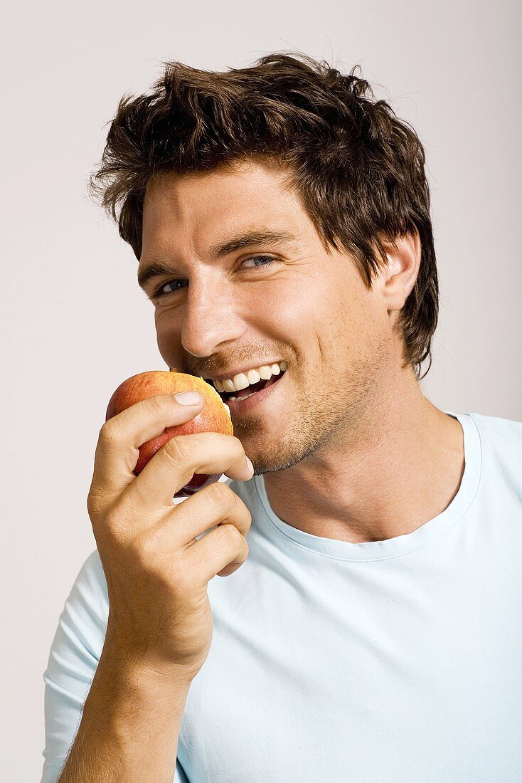 Young man holding apple, portrait