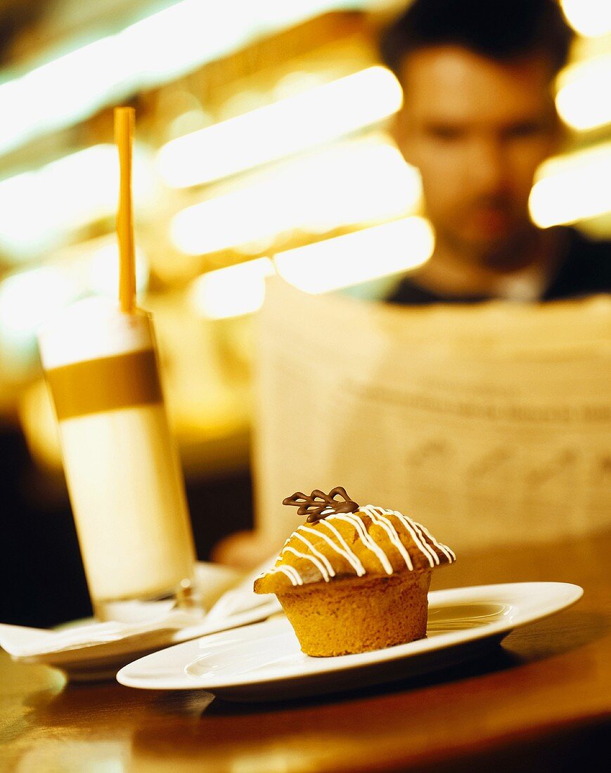 Muffin und Kaffee im Restaurant, Mann liest Zeitung