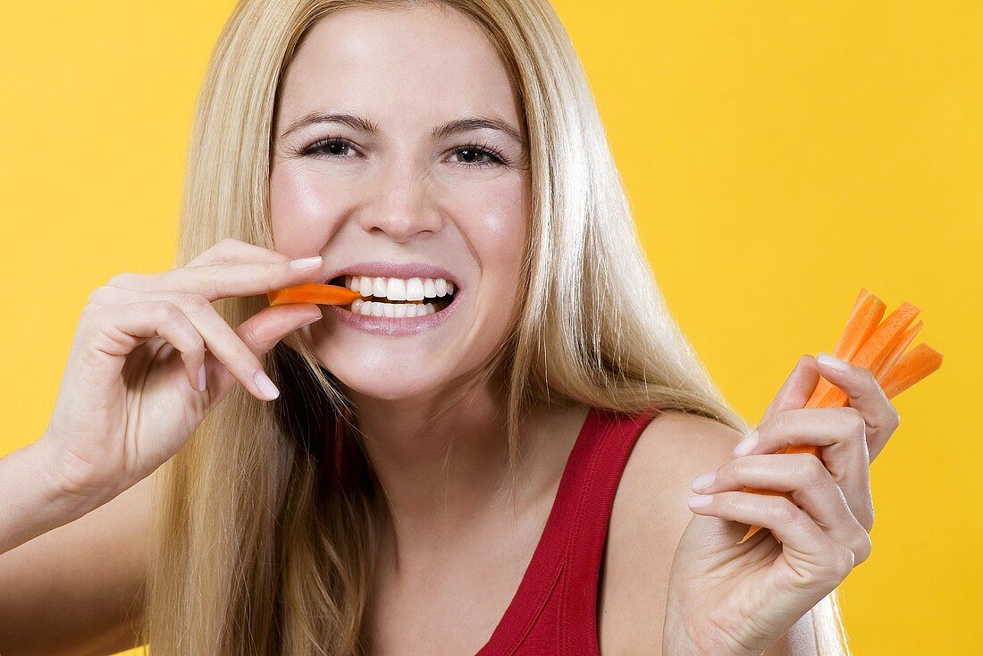 Woman eating carrot, close-up