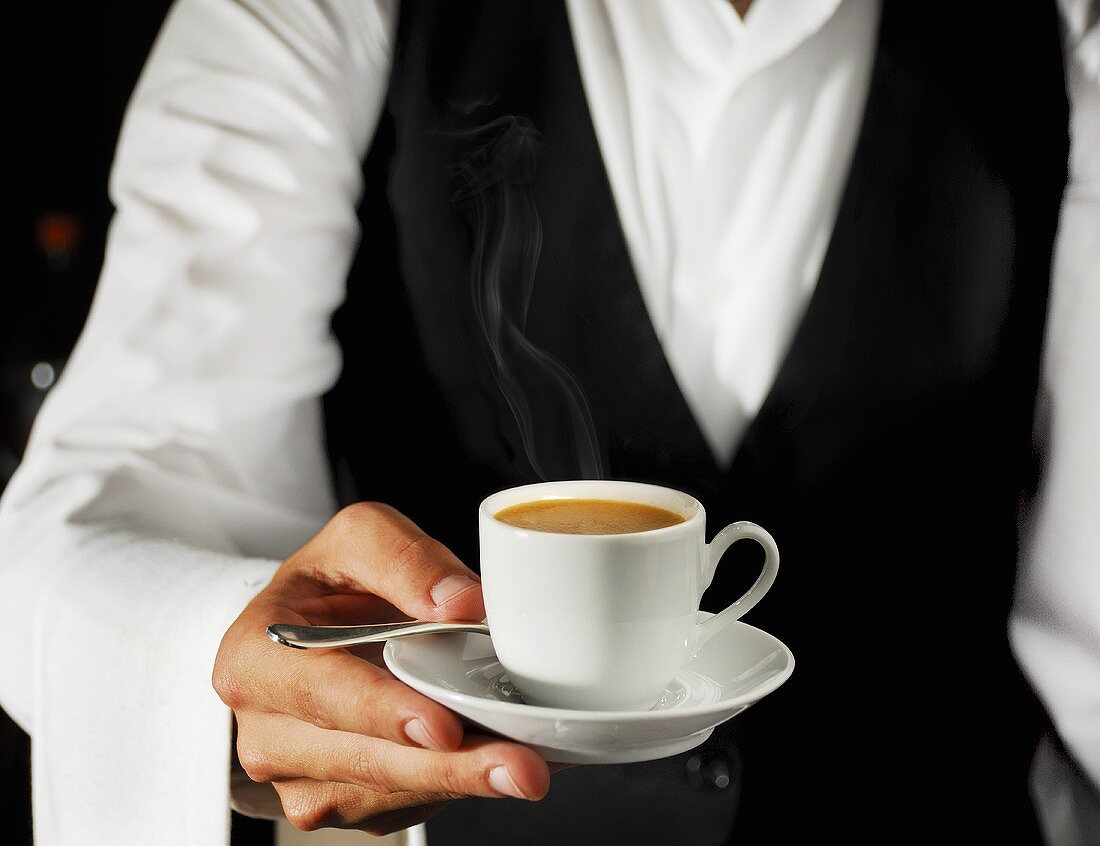 Waiter serving espresso