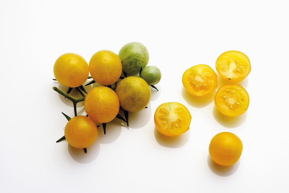 Ganze und halbierte gelbe Tomaten
