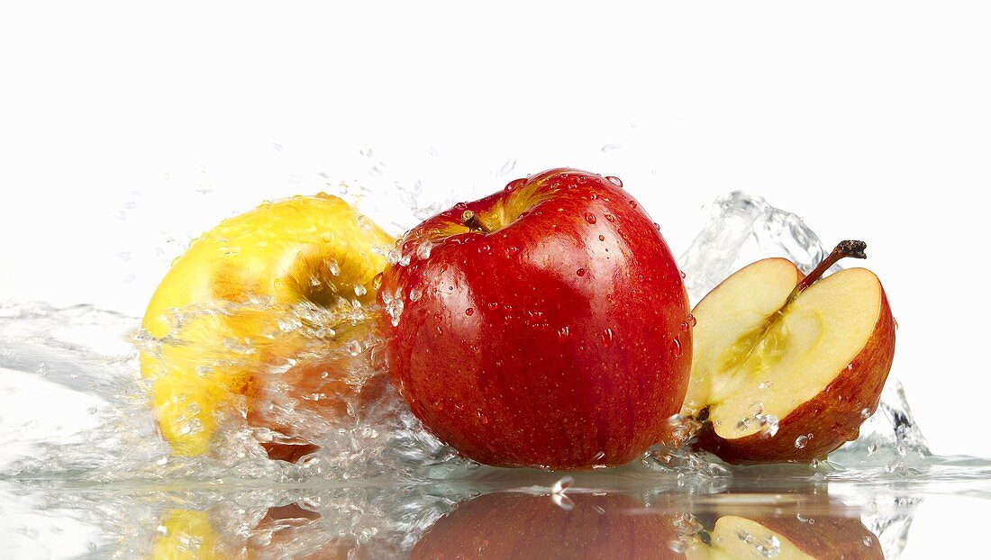 Red and yellow apples with splashing water