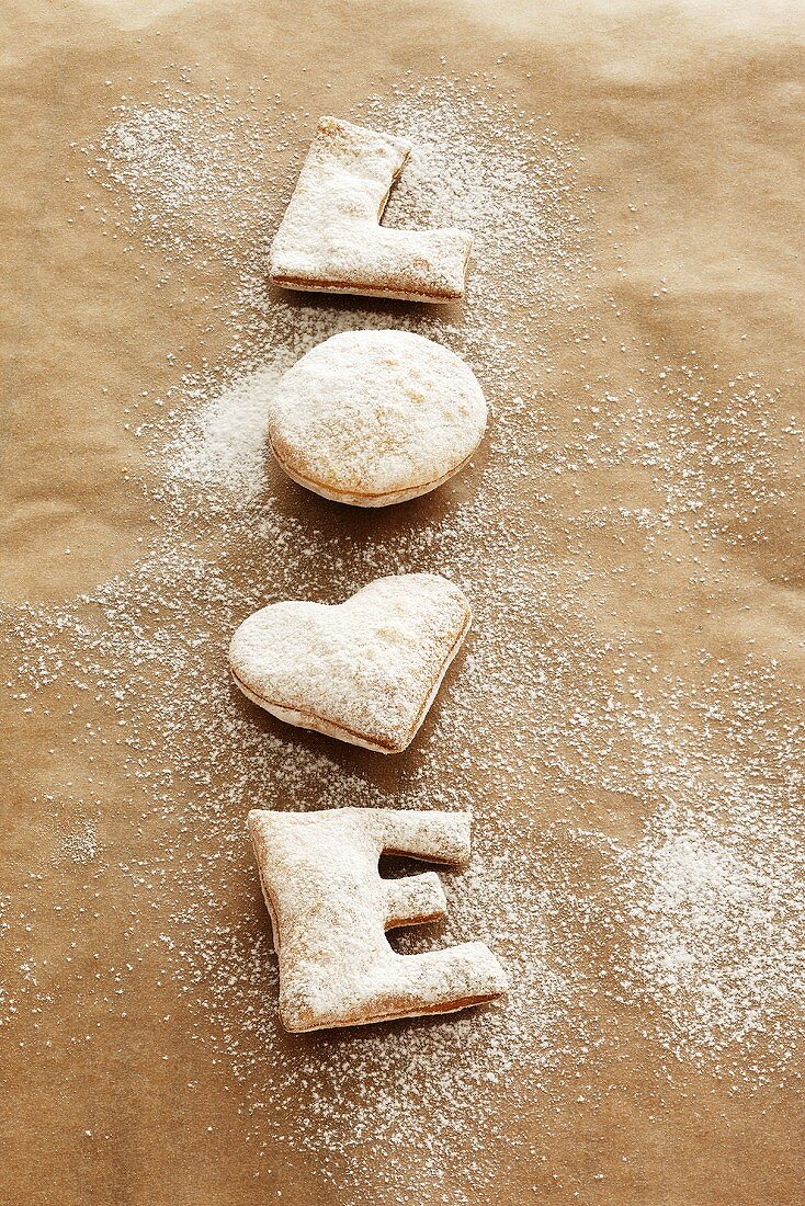 Freshly baked 'LOVE' biscuits with icing sugar